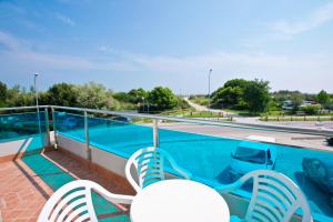 丽都阿德里亚诺Hotel-Residence-b&b Le Dune beach service included的一个带两把椅子的阳台和一个游泳池