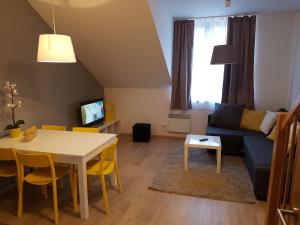 ein Wohnzimmer mit einem Tisch und einem Sofa in der Unterkunft Apartmán NA SVAHU 3+KK, Dolní Morava in Dolní Morava