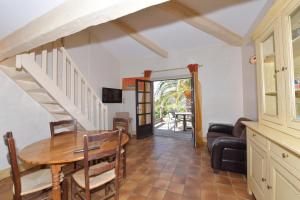 a living room with a wooden table and a staircase at Les Lauriers Roses in Rayol-Canadel-sur-Mer