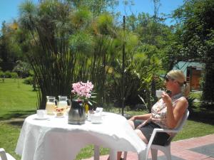 uma mulher sentada à mesa com uma chávena de café em La Posta de la Laguna em La Paloma