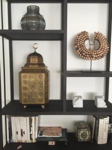 a black book shelf with a lantern and books at Le 5 ter in Tunis