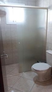 ein Badezimmer mit Toilette und Glasdusche in der Unterkunft Casa da Vó Nelsi in Gramado