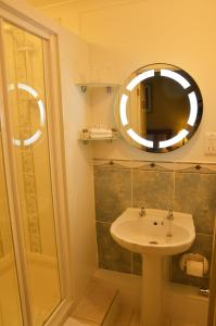 W łazience znajduje się umywalka i lustro. w obiekcie Bryn Hebog w mieście Carmarthen