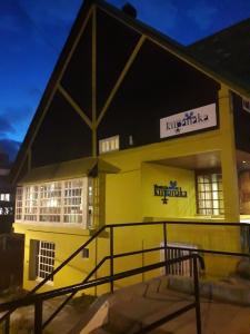 un gran edificio amarillo con un cartel. en Hosteria Kupanaka en Ushuaia