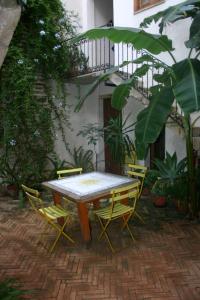 a table and chairs in a courtyard with a balcony at Il Cortiletto in Trapani