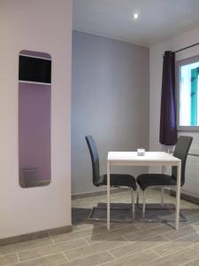 a table and chairs in a room with a purple wall at Les Victoriennes in Verdun-sur-Meuse