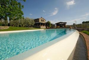 a large swimming pool with a house in the background at Special and Nice close to the Chianti in Bucine