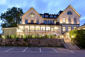 a large white house with lights in a parking lot at 1909 Sigtuna Stads Hotell in Sigtuna