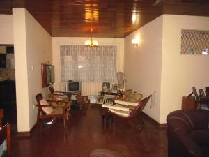 ネゴンボにあるMama's Hostel by Taprobaneのリビングルーム(椅子、テーブル、テレビ付)
