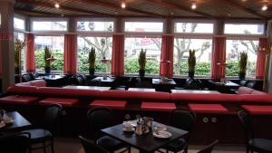 a restaurant with red couches and tables at Hotel Böll Essen in Essen