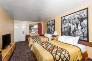 a hotel room with two beds and a flat screen tv at Hotel Zion Inn, Zion National Park Area in Hurricane