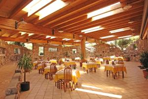 a restaurant with yellow tables and chairs in a building at Hotel La Pergola in Moniga