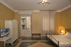 Dormitorio con cama, escritorio y TV en Holiday Pisa Gare, en Pisa