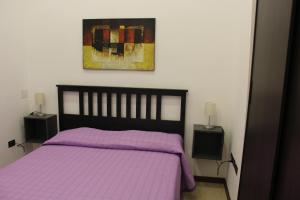 ナポリにあるLa Piazza - Garibaldi 2.6のベッドルーム1室(紫色のベッド1台、ナイトスタンド2台付)