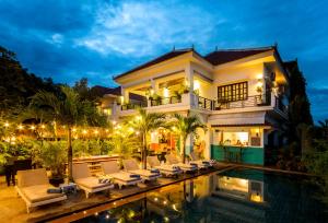 a villa with a swimming pool at night at Baby Elephant Boutique Hotel in Siem Reap