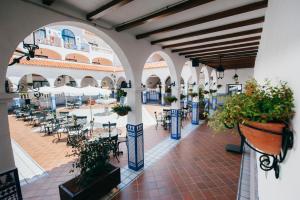 an indoor courtyard with tables and chairs and potted plants at Beverly Hills Heights - Excel Hotels & Resorts in Los Cristianos