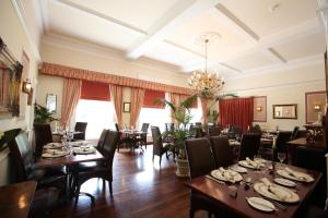 a dining room with tables and chairs and a chandelier at Fernhill Hotel in Lyme Regis