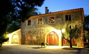 a large stone building with red doors on it at Villa Ceppeto in Monte San Savino
