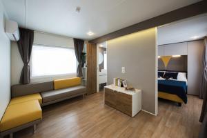 a bedroom with a couch and a bed and a mirror at Dune Prestige & Chalets in Bibione