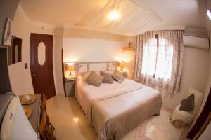 Un dormitorio con una cama grande y una ventana en Chalé Alto da Serra - Pousada & Wellness Spa, en São Joaquim