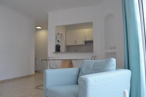 a living room with a blue couch and a kitchen at Paraiso 12 - 1bedroom in Playa Paraiso