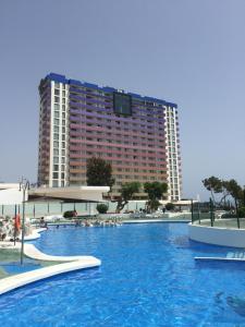 a large swimming pool with a large building in the background at Paraiso 12 - 1bedroom in Playa Paraiso