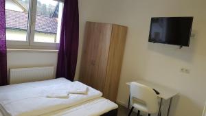 Kleines Zimmer mit einem Bett und einem TV an der Wand in der Unterkunft Gasthaus Sofram in Frastanz