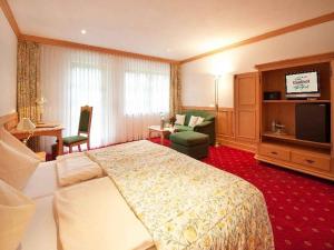 ein Hotelzimmer mit einem großen Bett und einem TV in der Unterkunft Hotel-Gasthof Zum Süßen Grund in Albstadt