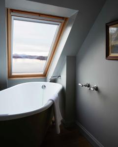 a bath tub in a bathroom with a window at Kinloch Lodge Hotel and Restaurant in Kinloch