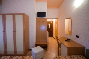 Habitación con 1 dormitorio con escritorio y espejo. en Hotel La Riviera, en Montecatini Terme