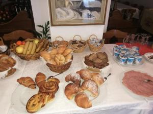 a table topped with baskets of bread and pastries at Hotel Fiames in Cortina dʼAmpezzo