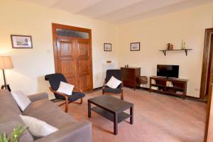 een woonkamer met een bank en stoelen en een televisie bij Casa Punta Amore-WelcHome in Cannobio
