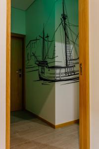 a painting of a ship on a wall in a room at Venceslau Wine Boutique Hostel in Vila do Conde