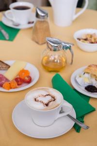 a table with a cup of coffee and plates of food at Alloro B&B in Florence