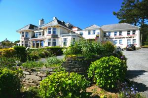 a large white house with a stone wall at Porth Avallen Hotel in St Austell