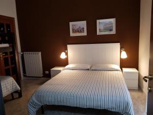 チャンピーノにあるLa Dolce Vita Rome Ciampinoのベッドルーム1室(白い大型ベッド1台、照明2つ付)