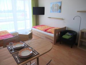 um pequeno quarto com uma cama e uma mesa com uma mesa em Apartmán u Aurory em Třeboň