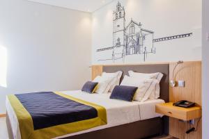 
a hotel room with a bed and a lamp at Venceslau Wine Boutique Hostel in Vila do Conde
