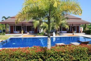 eine Villa mit einer Palme und einem Pool in der Unterkunft Waterside Resort in Pran Buri