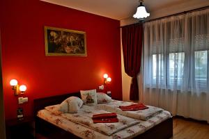 a bedroom with a bed with red walls and a window at Casa Nobilium in Turda