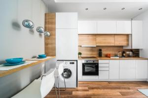 ブダペストにあるRákóczi Stylish Entire Apartmentのキッチン(白いキャビネット、洗濯機、乾燥機付)