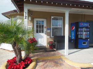 a house with a palm tree in front of a gas station at Budget Inn - Saint Augustine in Saint Augustine