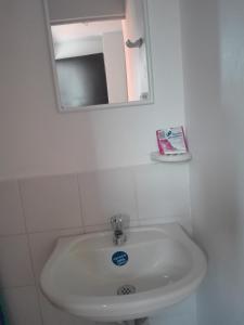 lavabo blanco en el baño con espejo en Rio Hotel Montería, en Montería