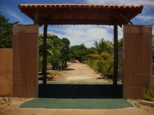 an entrance to a garden with a wooden pavilion at Pousadinha Mangabeiras Familia e Grupos in Guriri
