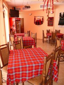 um restaurante com mesas e cadeiras com cobertores vermelhos e brancos em Sveti Georgi Family Hotel em Varshets
