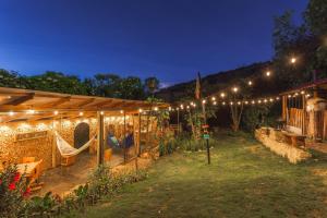 un giardino con patio dotato di altalena e luci di Casa Agrreste a Sopó