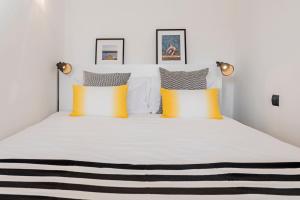 a bedroom with a bed with yellow and grey pillows at Varandas do Funchal I by An Island Apart in Funchal +19 photos