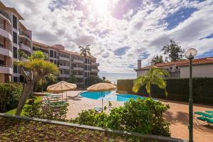 a swimming pool with umbrellas in a resort at Varandas do Funchal I by An Island Apart in Funchal