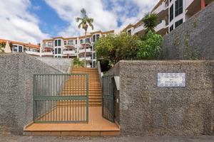 a gate in a wall with stairs and a building at Varandas do Funchal I by An Island Apart in Funchal