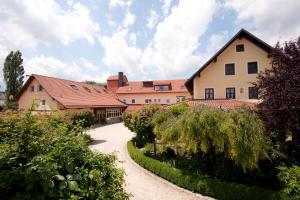 ein Haus mit einem Weg, der zu einem Gebäude führt in der Unterkunft Stadler Hof in Großgundertshausen